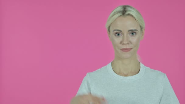 Young Woman Showing Product with Hand, Pink Background - Video, Çekim