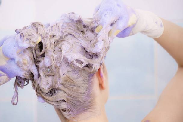 Woman applying toner shampoo on her hair - Valokuva, kuva