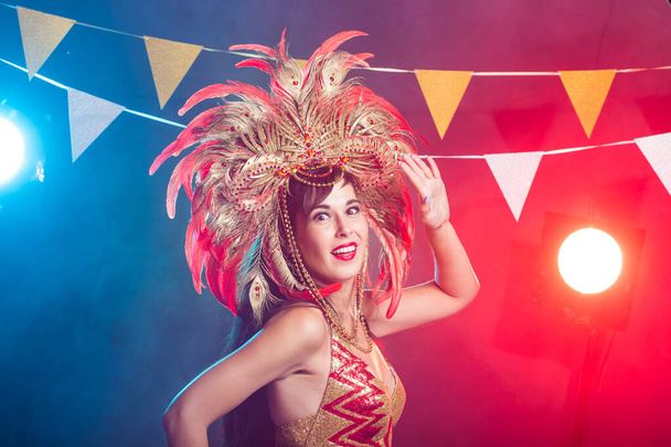 Concept carnaval, danseur et vacances - Femme brune beauté en costume de cabaret et coiffure avec plumes naturelles et strass
. - Photo, image