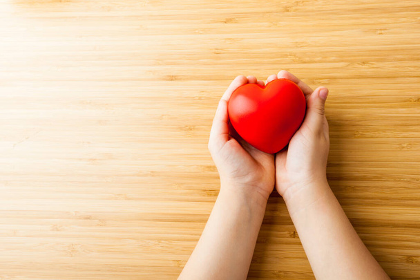 child hands holding red heart, health care, donate and family insurance concept - 写真・画像