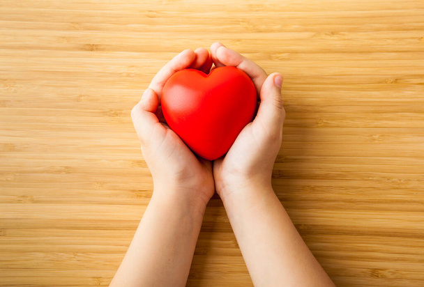 child hands holding red heart, health care, donate and family insurance concept - 写真・画像