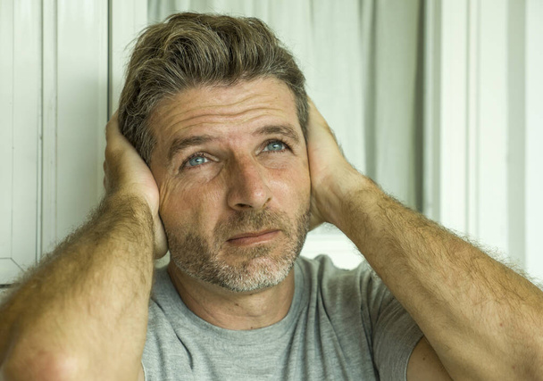dramatic portrait of middle aged sad and depressed man in pain feeling stressed and frustrated suffering depression problem and anxiety crisis looking gloomy - 写真・画像