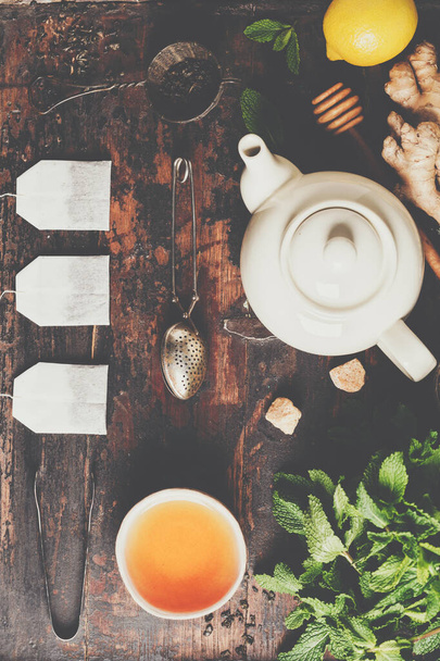 Tea composition on rustic background: tea, mint, lemon, ginger. - Photo, image