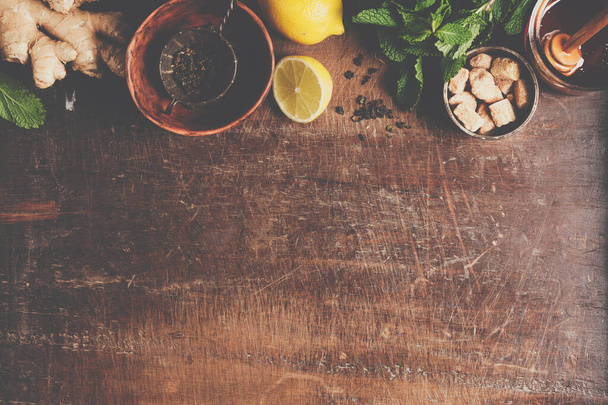 Tea composition on rustic background: tea, mint, lemon, ginger. - Foto, afbeelding
