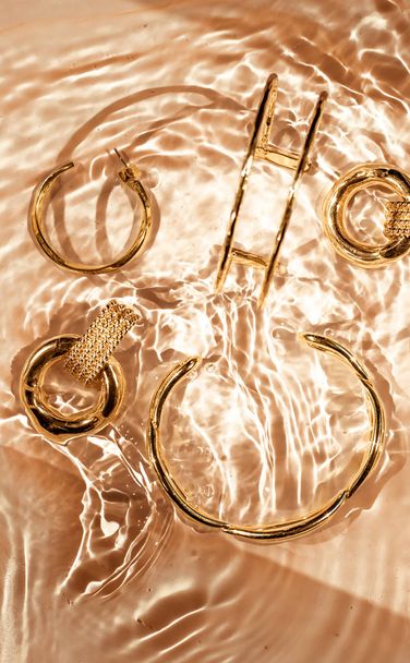 Золотые браслеты, серьги, кольца, ювелирные изделия на золотой воде backgr
 - Фото, изображение