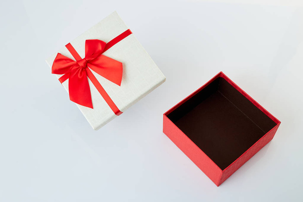 Bílá dárková krabička s červenou stuhou na bílém - Fotografie, Obrázek