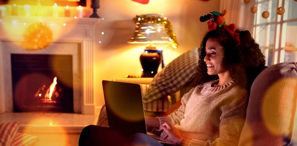 Composite image of brown parquet against woman using laptop at home at christmas time - Fotoğraf, Görsel