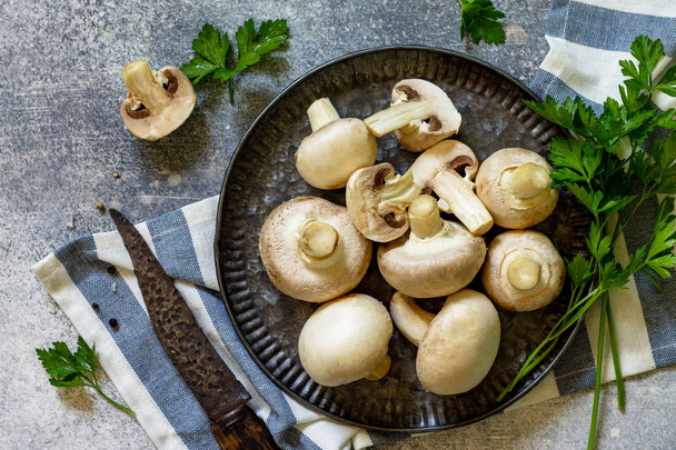 Champignons. Fresh white mushrooms in bowl on stone background.  - Foto, Imagen
