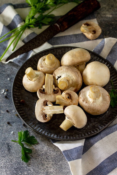 Champignons. Fresh white mushrooms in bowl on stone background.  - Φωτογραφία, εικόνα