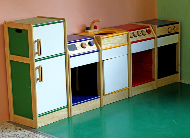 Holzspielzeugküche zum Spielen und Amüsieren der Kinder einer Kinderkrippe - Foto, Bild