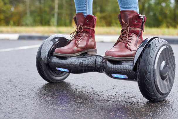 Close up of woman using hoverboard on asphalt road. Feet on elec - Photo, Image