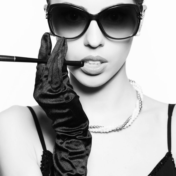 Portrait of a fashionable model in vintage sunglasses with a cig - Photo, image