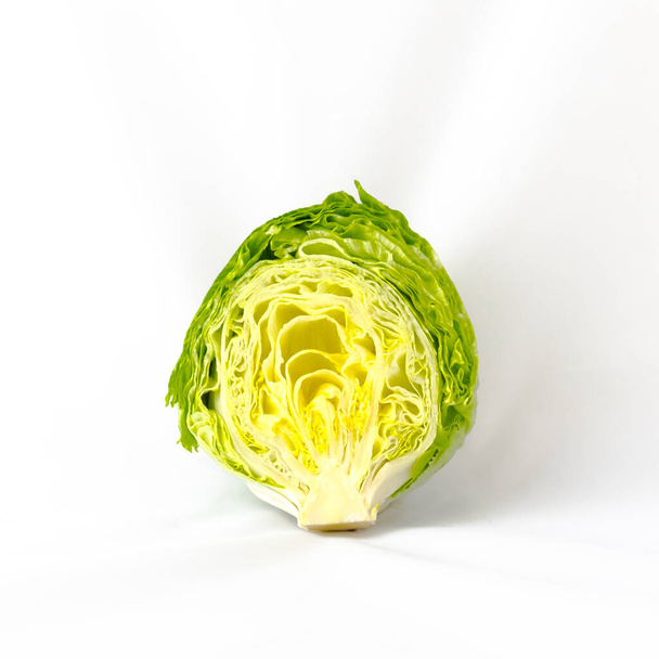 Studio shot half cut of organic iceberg lettuce isolated on white - Photo, Image