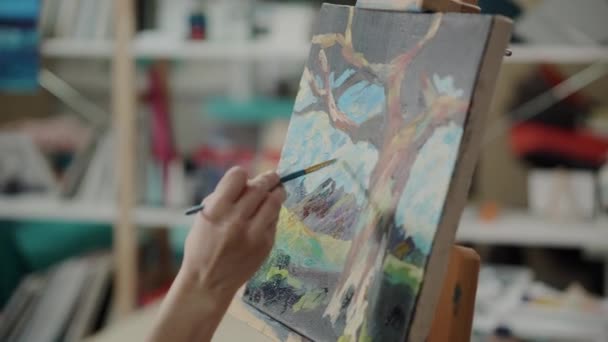 Γυναίκα απεικονίζει το τοπίο σε καμβά από ακρυλικά χρώματα στο στούντιο - Πλάνα, βίντεο