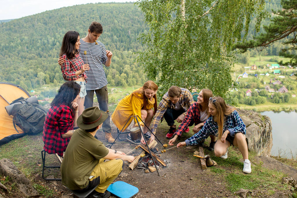 a group of young people cooking supper outdoors - Foto, immagini