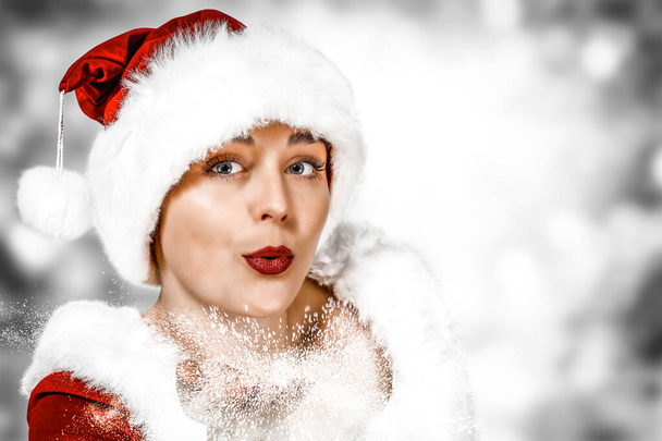 Jonge Santa Claus vrouw met witte achtergrond van besneeuwde winter kerstdag. - Foto, afbeelding