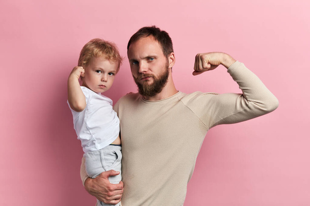 strong man and his son showing their biceps - Foto, afbeelding