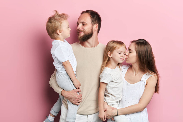 young daddy and mommy kissing their kids - Фото, изображение