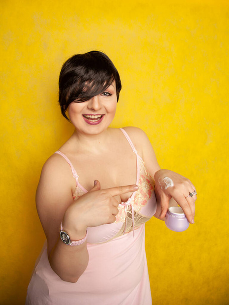 Ελκυστική κοπέλα βάζει αντιγηραντική κρέμα στο χέρι της παλάμης της - Φωτογραφία, εικόνα