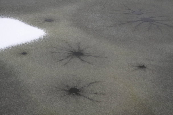 Küçük bir gölün buzundaki çatlaklar. Doğal olgu ve tehlike - Fotoğraf, Görsel