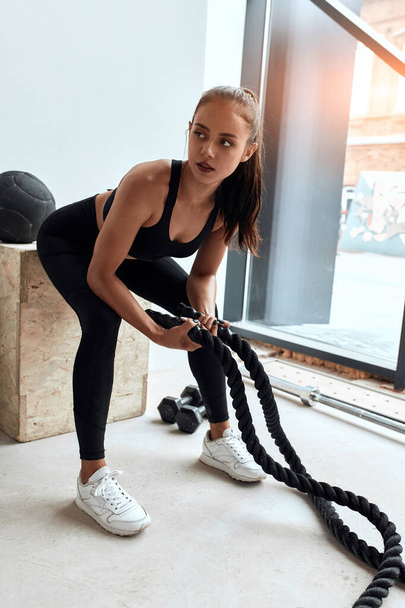Sporty woman in sportswear holding crossfit rope - Photo, Image
