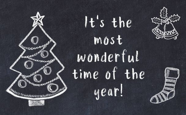 Karácsonyfa rajza és kézzel írott üdvözlet fekete táblán  - Fotó, kép
