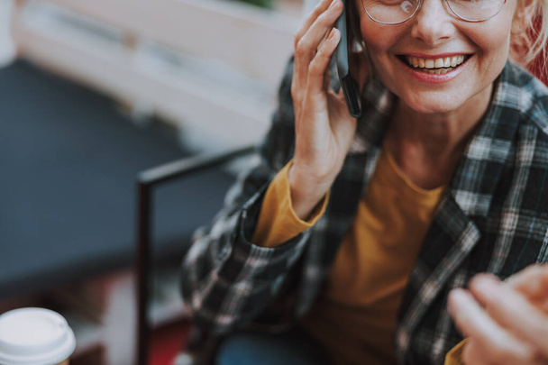Cheerful lady in eyeglasses talking on the smartphone - Foto, Imagen