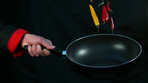 Super powolny ruch kucharza trzymającego smażenie z spadającą papryką chili. Nagrywane na szybkim aparacie kinowym, 1000fps. - Materiał filmowy, wideo