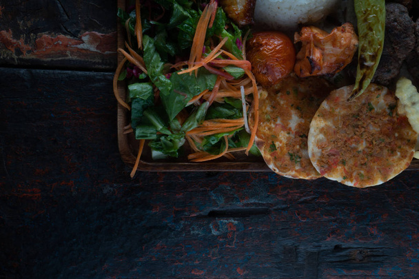 Close-up bovenaanzicht van gemengde Turkse kebab plaat geïsoleerd op rustieke houten tafel  - Foto, afbeelding