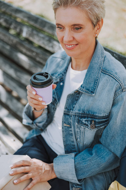 Female holding a paper cup of coffee - Zdjęcie, obraz
