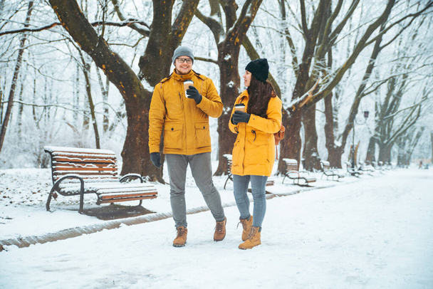 Para spacerująca zasypani city Park rozmowy, towarzyskich. romantyczną randkę w okresie zimowym - Zdjęcie, obraz
