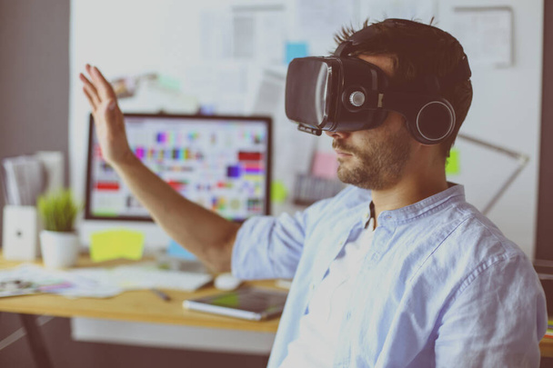 Młody programista męski testujący nową aplikację z okularami 3D wirtualnej rzeczywistości w biurze. - Zdjęcie, obraz