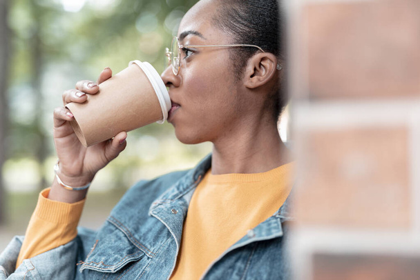 Young woman sipping hot drink outdoors stock photo - Foto, Imagem