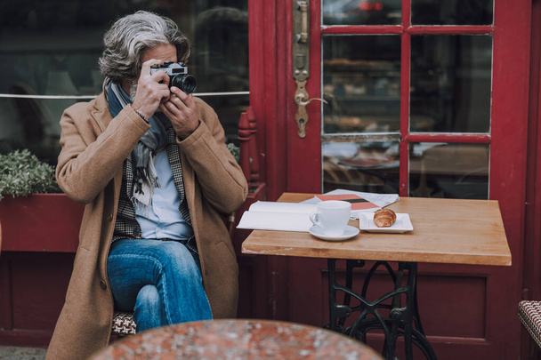 Mature photographer at the cafe table stock photo - Photo, image