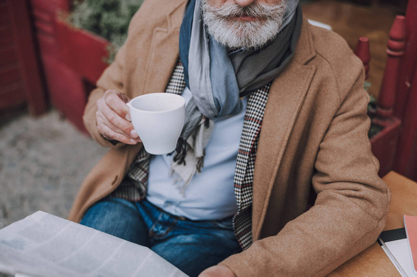 Man in coat drinking coffee stock photo - Fotoğraf, Görsel