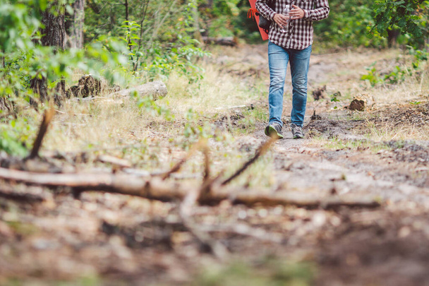 Молодий чоловік ходить у лісі. Він досліджує ліс, насолоджується осіннім днем, тримаючи пляшку на відкритих лісових пейзажах. Пригоди пішохідні. Концепція свободи зовнішнього способу життя
. - Фото, зображення