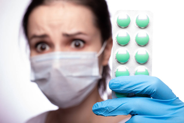 jeune femme dans un coquelicot médical et gants avec une pilule
 - Photo, image