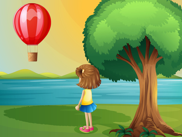 Девушка смотрит воздушный шар на берегу реки
 - Вектор,изображение