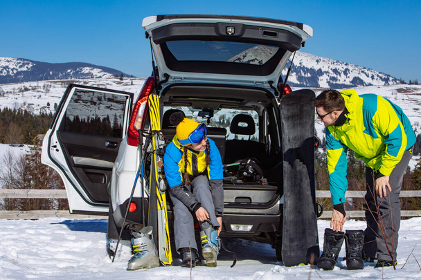 homem e mulher vestir-se em equipamento de esqui perto de carro SUV - Foto, Imagem