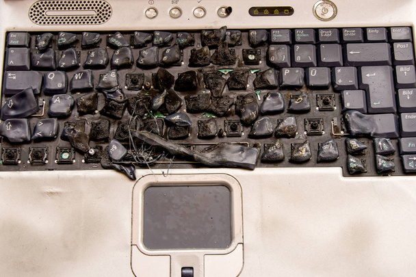 Клавиатура расплавленного ноутбука, короткое замыкание, огнеопасное офисное оборудование
 - Фото, изображение