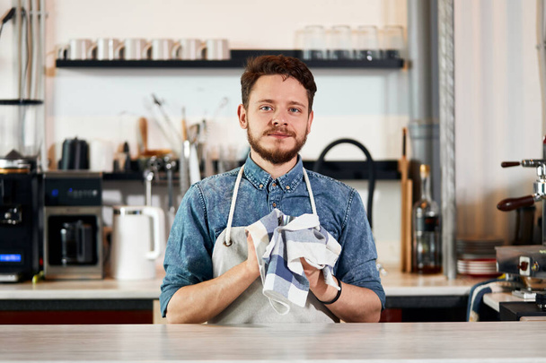 Handsome male barista working at counter - Foto, afbeelding