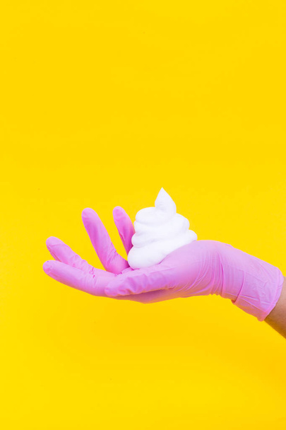 Shaving foam on a hand on a yellow background. - Фото, зображення