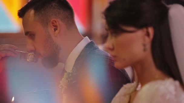 Збільшений профіль зображення нареченої та нареченого у православній церкві під час весільної церемонії.. - Кадри, відео