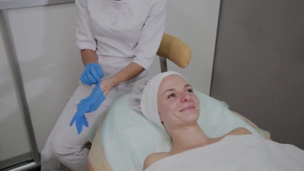 Professional cosmetologist wears blue rubber gloves for the procedure. - Footage, Video