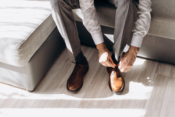 A man wears shoes. Going to work. He ties his shoelaces. - Fotó, kép