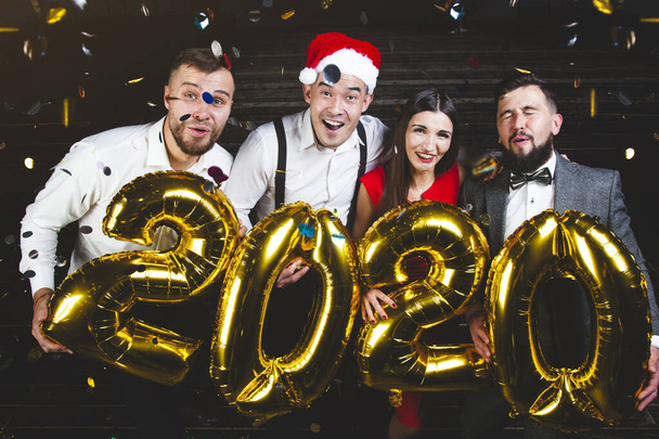 Beautiful young people at a corporate party holding balloons 2020. New Year celebration. Club party with friends - Fotografie, Obrázek