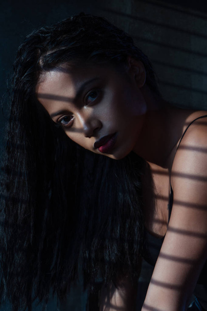 Retrato de mujer sensual en top negro con una sombra rayada de las persianas
 - Foto, Imagen