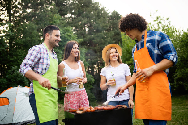 Small group of friends drinking alcohol and having a meal at barbecue party - Photo, image