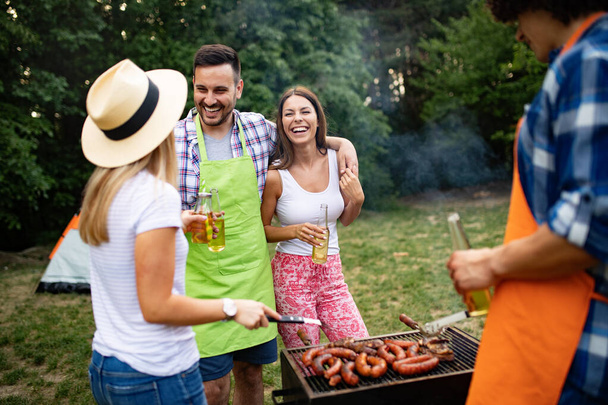 Friends having a barbecue party in nature while having a blast - Foto, Bild
