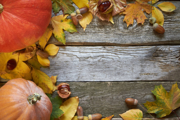 Φθινοπωρινό φόντο Ευχαριστιών σε σκούρα ξύλινη επιφάνεια, κολοκύθες, μαραμένα φύλλα, βελανίδια και κάστανα, επιλεκτική εστίαση - Φωτογραφία, εικόνα